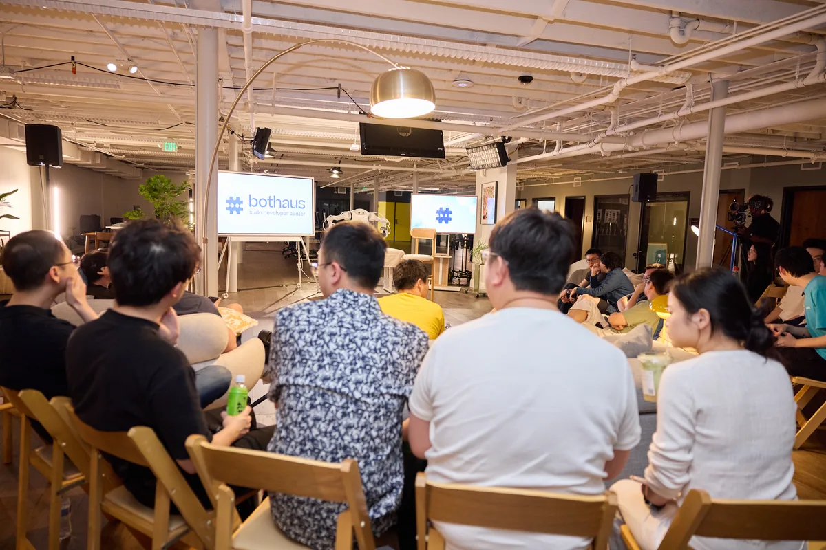 An audience watches a talk at a bothaus community event